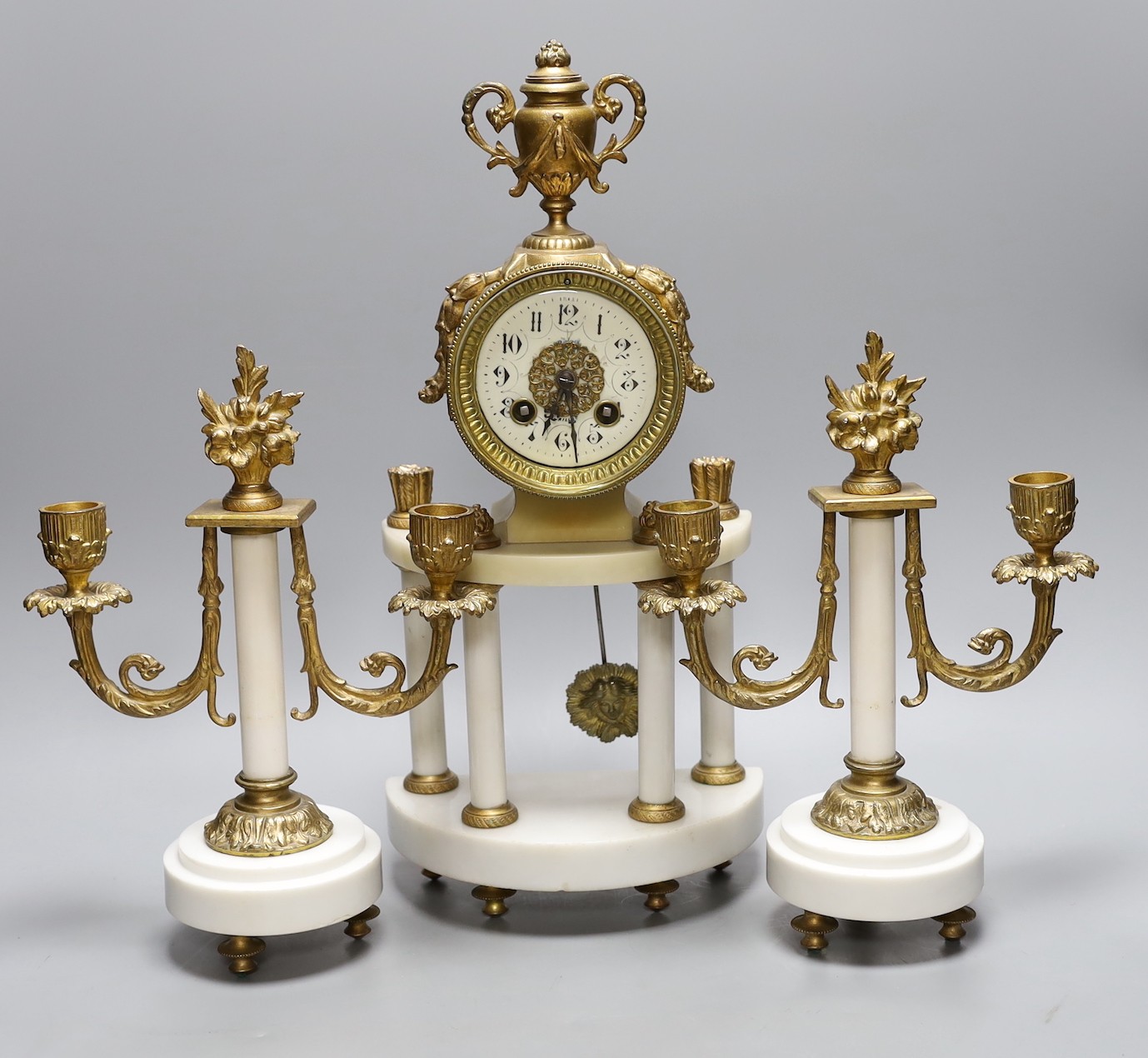 A French white marble and gilt metal clock garniture, 43 cms high